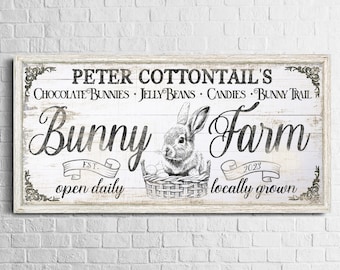 May include: A white wooden sign with black text that reads "Peter Cottontail's Bunny Farm Est. 2023 Open Daily Locally Grown". The sign also features a black and white illustration of a bunny in a basket with eggs.