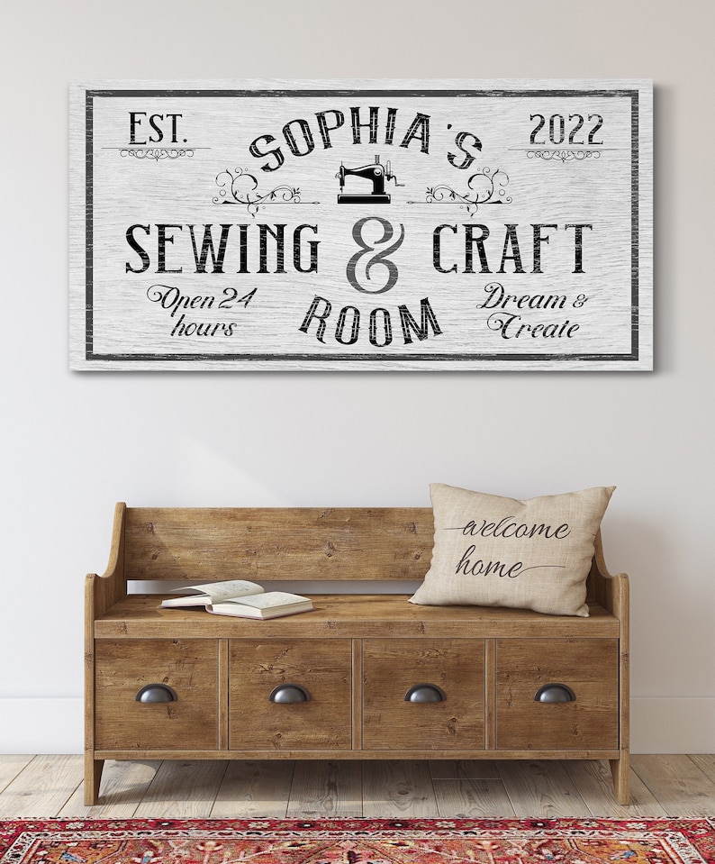 Puede incluir: Un letrero de madera blanco con texto negro que dice "EST. Sophia's 2022 Costura & Artesan&iacute;a Sala Abierto 24 horas So&ntilde;ar & Crear". El letrero presenta un gr&aacute;fico de m&aacute;quina de coser vintage.