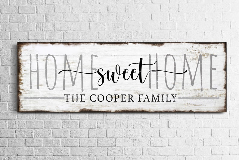 May include: White wooden sign with the text "Home sweet Home" in black cursive lettering and "The Cooper Family" in gray lettering below.