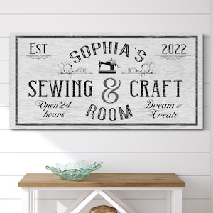 Puede incluir: Un letrero de madera blanco con texto negro que dice "EST. 2022 SOPHIA'S SEWING & CRAFT ROOM Open 24 hours Dream & Create". Una ilustraci&oacute;n en blanco y negro de una m&aacute;quina de coser est&aacute; sobre el texto.