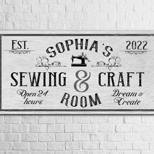 Puede incluir: Un letrero de madera blanco con texto negro que dice "EST. 2022 Sophia's Sewing & Craft Room Open 24 hours Dream & Create". El letrero presenta un gr&aacute;fico de m&aacute;quina de coser vintage.