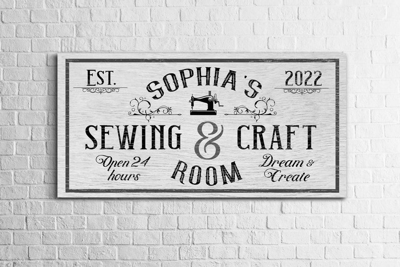 Puede incluir: Un letrero de madera blanco con texto negro que dice "EST. 2022 Sophia's Sewing & Craft Room Open 24 hours Dream & Create". El letrero presenta un gr&aacute;fico de m&aacute;quina de coser vintage.