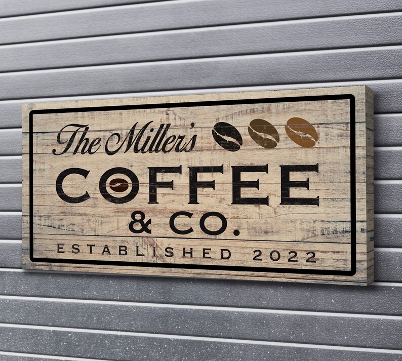 May include: A rustic wooden sign with the text "The Millers Coffee & Co. Established 2022" in black lettering. The sign features three brown coffee beans.