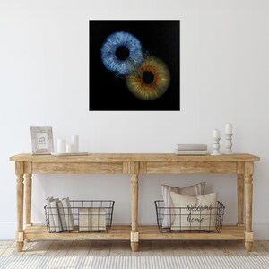 May include: Two close-up images of human irises, one blue and one brown, on a black background.