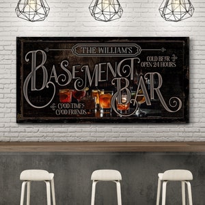 May include: A black and brown sign with the text "The William's Basement Bar" and "Cold Beer Open 24 Hours". The sign also has the text "Good Times Good Friends" and features a variety of drinks in glasses.