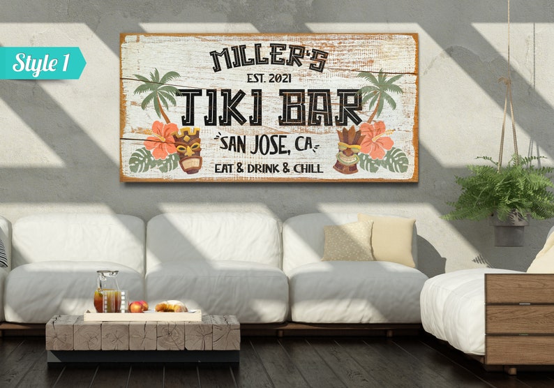 K&ouml;nnte beinhalten: Ein rustikales Holzschild mit dem Text "MILLER'S EST. 2021 TIKI BAR SAN JOSE, CA EAT & DRINK & CHILL". Das Schild zeigt Palmen, tropische Blumen und Tiki-Masken.
