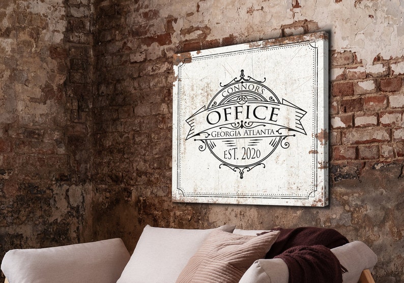 May include: A white canvas sign with black text that reads "Connors Office Georgia Atlanta Est. 2020". The sign is hanging on a brick wall.