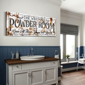 May include: A white bathroom vanity with a brown countertop and three drawers. A white porcelain sink with a chrome faucet is on the countertop. A rusty metal sign above the vanity reads "The Williams' Powder Room Open All Hours Seat Yourself".