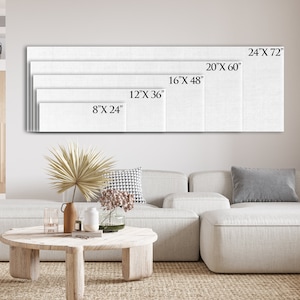 May include: A white canvas print with different size options displayed on a wall above a white sectional sofa. The sizes are 8" x 24", 12" x 36", 16" x 48", 20" x 60", and 24" x 72".