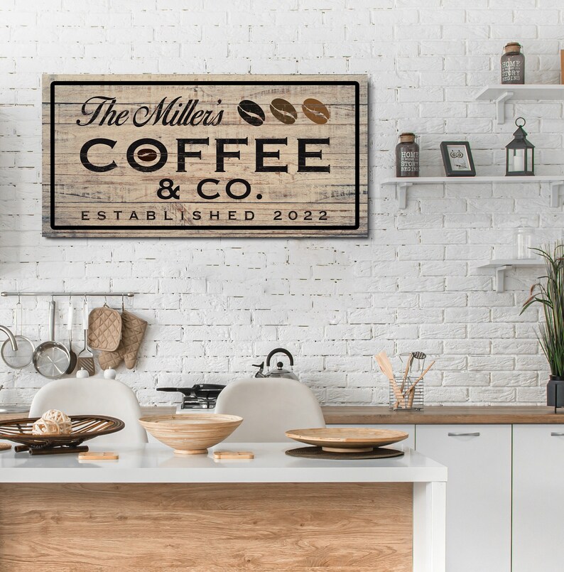 May include: A rustic wooden sign with the text "The Miller's Coffee & Co. Established 2022" in black lettering. Three coffee beans are depicted above the text.