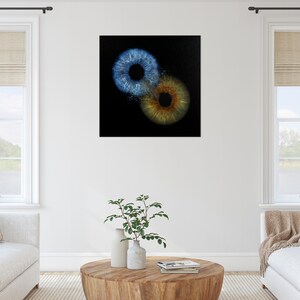 May include: Abstract art print featuring two overlapping irises, one blue and one brown, on a black background.