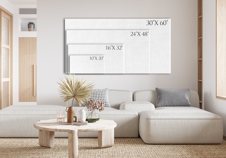 Op de afbeelding: Vier witte canvas kunstprints van verschillende formaten worden op een muur getoond. De formaten zijn 25,4 cm x 50,8 cm, 40,6 cm x 81,3 cm, 61 cm x 122 cm en 76,2 cm x 152,4 cm. De prints zijn boven een lichtgekleurde bank.