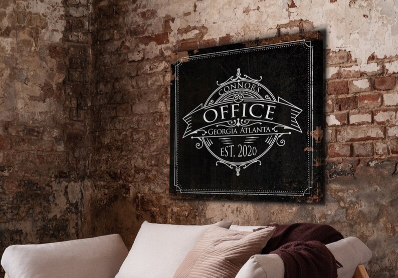 May include: Black and white sign with the text "Connors Office Georgia Atlanta Est. 2020" in a vintage style font. The sign is hanging on a brick wall.