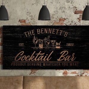 May include: Black wooden sign with white text that reads "The Bennett's Est. 2022 Cocktail Bar Proudly Serving Whatever You Want". The sign has a distressed look and features a row of gold cocktail glasses.