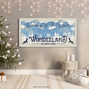 May include: A blue and white sign with the text "Walking in the Winter Wonderland - The Smith Family". The sign features a winter scene with snow-covered houses and trees, and two deer.