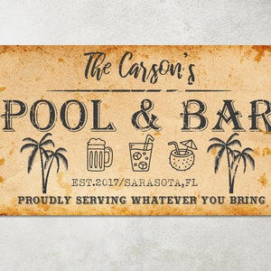 May include: A vintage-style sign with the text "The Carson's Pool & Bar Est. 2017/Sarasota, FL Proudly Serving Whatever You Bring". The sign features palm trees, a beer mug, a glass of ice with a straw, and a coconut with a straw and umbrella.