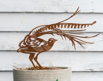 Könnte beinhalten: Eine rostbraune Metallskulptur eines Vogels mit ausgebreiteten Flügeln, platziert in einem Betonpflanzgefäß. Das filigrane Design des Vogels ist vor einem weißen Holzhintergrund zu sehen. Der Pflanztopf trägt den Text "CUSTOM STEEL APPEAL".