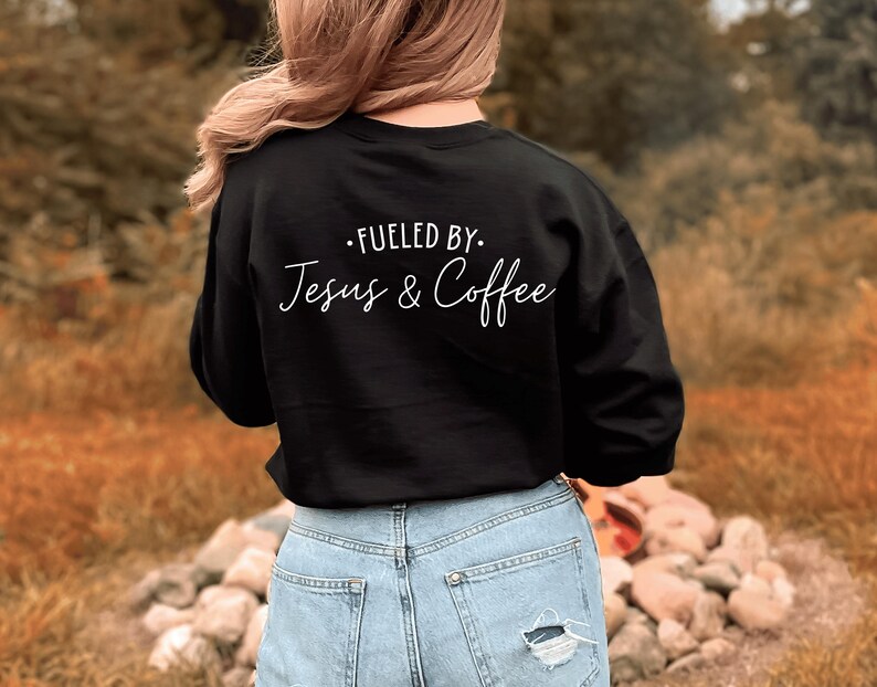 May include: Black sweatshirt with white text that reads "Fueled by. Jesus & Coffee".