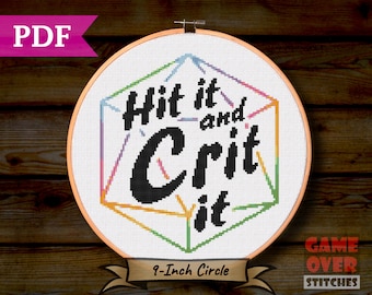 Op de afbeelding: Een kruissteekontwerp in een hoepel van 22,86 cm. Het ontwerp toont de tekst "Hit it and Crit it" in zwart, met een kleurrijke geometrische vorm. De PDF-download is van Game Over Stitches.