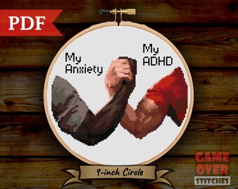 May include: Cross-stitch pattern of two arms arm wrestling, one labeled "My Anxiety" and the other "My ADHD". The pattern is in a 9-inch embroidery hoop.