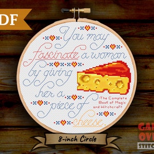 May include: A cross-stitch pattern for an 8-inch embroidery hoop featuring a piece of cheese and the text "You may fascinate a woman by giving her a piece of cheese." The text is in blue and red, and the cheese is yellow with red and white accents. The text "The Complete Book of Magic and Witchcraft" is also included in the pattern.