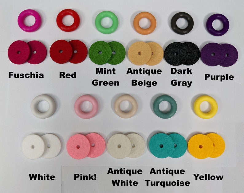 Op de afbeelding: Assortiment van kleurrijke ronde houten ringen en schijven in verschillende kleuren, waaronder fuchsia, rood, mintgroen, antiek beige, donkergrijs, paars, wit, roze, antiek wit, antiek turquoise en geel.
