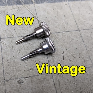 May include: Two silver screws, one labeled "New" and the other labeled "Vintage". The screws are on a gray textured surface.