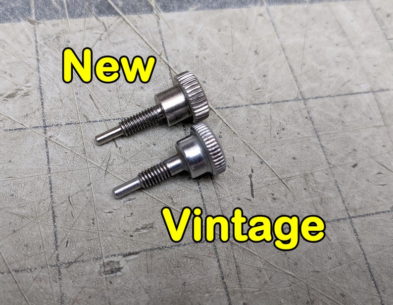 May include: Two silver screws, one labeled "New" and the other labeled "Vintage". The screws are on a gray textured surface.