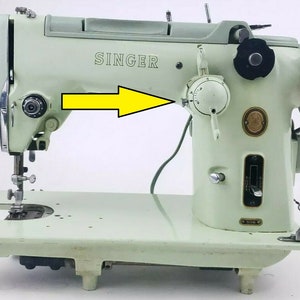 May include: A vintage Singer sewing machine in a light green color. The machine has a metal foot pedal and a knob for adjusting the stitch length. The machine is in good condition and has a few minor scratches.