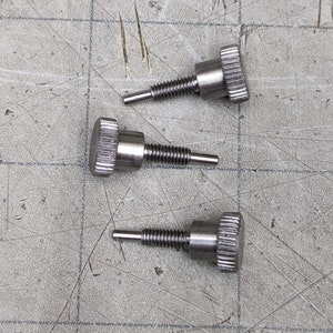 May include: Three silver-toned thumbscrews with a knurled head and a threaded shaft.