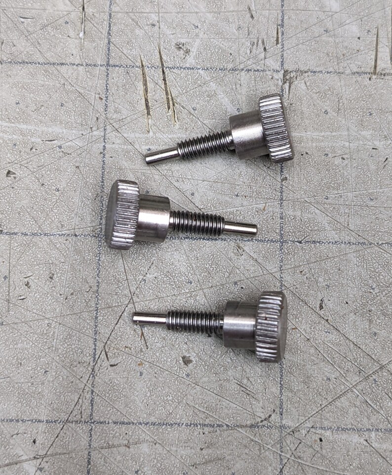 May include: Three silver-toned thumbscrews with a knurled head and a threaded shaft.