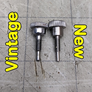 May include: Two silver metal knobs, one labeled "vintage" and the other "new". The knobs are similar in design but have slight differences in their finish.