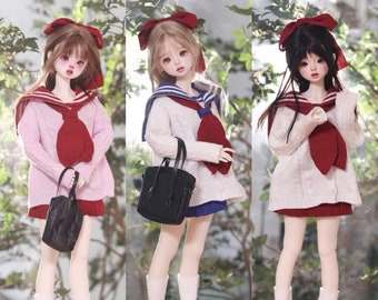May include: Three dolls wearing sailor-style outfits with red bows, white sweaters, and red and blue skirts. Each doll is holding a black handbag and wearing white socks and black shoes.