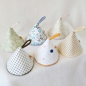 May include: Five different patterned pot holders in various colors and designs. The pot holders are shaped like small cones and have a loop for hanging.