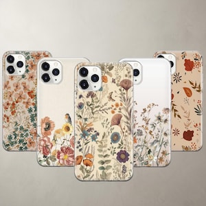 May include: Five smartphone cases featuring various botanical and floral designs. The cases display illustrations of wildflowers, leaves, and small birds in muted earth tones, including orange, brown, blue, and cream, with cutouts for camera lenses.
