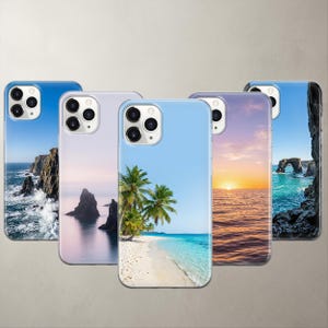 A product collage displaying five photorealistic nature phone cases for Apple iPhone and Google Pixel models. The designs feature breathtaking high-definition coastal photography, including dramatic ocean cliffs, mystic sea rocks, a vibrant tropical beach, a golden ocean sunset, and a coastal stone arch, all set against perfectly clean, clear blue skies.