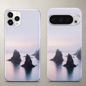 Scenic nature phone case featuring a calming view of mystic dark sea rocks resting in still water under a clear, soft pastel sky.