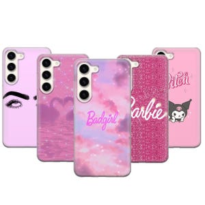 Può includere: Una collezione di custodie per telefoni rosa con vari design. Una custodia presenta un design a occhio, un'altra ha dei cigni, una terza mostra il testo "Badgirl", una quarta ha la parola "Barbie" e l'ultima ha un personaggio dei cartoni animati.