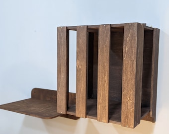 May include: A dark brown wooden wall shelf with a rectangular open shelf and a smaller shelf below. The shelf is mounted to a white wall.