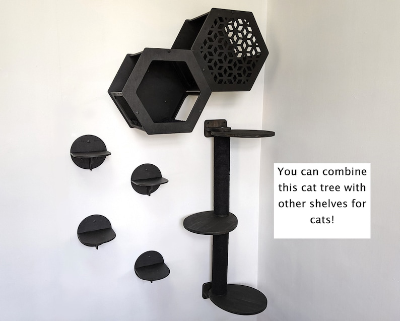 May include: Black cat tree with multiple shelves and a hexagonal cat condo. The cat tree is mounted on a wall and has a post with a scratching surface. The text "You can combine this cat tree with other shelves for cats!" is visible in the image.