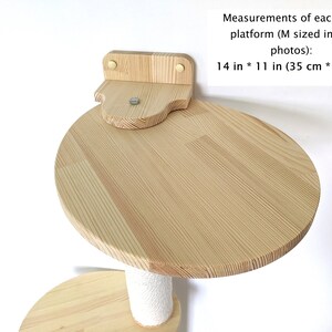 Pu&ograve; includere: Un albero per gatti in legno con una piattaforma rotonda di 35 cm per 28 cm, fissata al muro. La piattaforma &egrave; in legno naturale e ha un colore marrone chiaro.