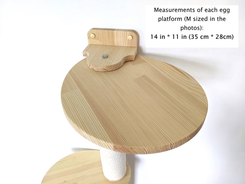 Pu&ograve; includere: Un albero per gatti in legno con una piattaforma rotonda di 35 cm per 28 cm, fissata al muro. La piattaforma &egrave; in legno naturale e ha un colore marrone chiaro.