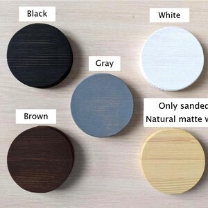 May include: Five wooden circles in different colors: black, white, gray, brown, and natural wood. The text "Only sanded or Natural matte waxed" is written below the circles.