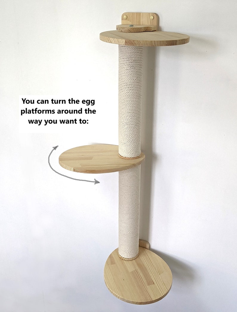 Pu&ograve; includere: Un albero per gatti da parete con finitura in legno naturale e un palo per grattare rivestito in sisal. Le piattaforme hanno la forma di un uovo e possono essere ruotate in diverse posizioni. Il testo "You can turn the egg platforms around the way you want to:" &egrave; visibile nell'immagine.