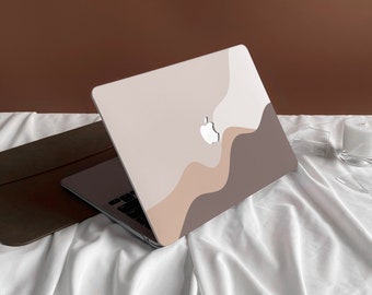 May include: A laptop computer with a white, beige, and brown abstract design on the lid. The laptop is closed and sitting on a white sheet.
