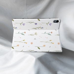 May include: White tablet case with a floral pattern featuring small purple, orange, and yellow flowers on a white background.