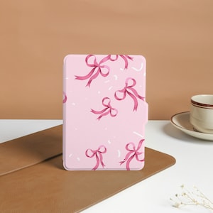 May include: Pink e-reader case with a pattern of pink bows on a white background.