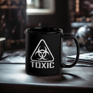 May include: Black coffee mug with a white biohazard symbol and the word "TOXIC" printed on it.