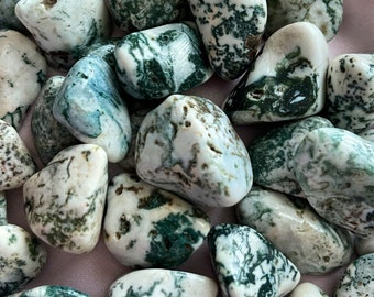 May include: A collection of moss agate tumbled stones. The stones are a mix of white and green with intricate patterns.