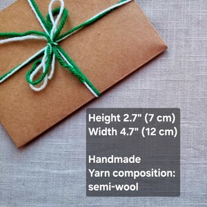 May include: A brown package tied with white and green yarn. The package is 2.7 inches (7 cm) high and 4.7 inches (12 cm) wide. The yarn is semi-wool and the package is handmade.